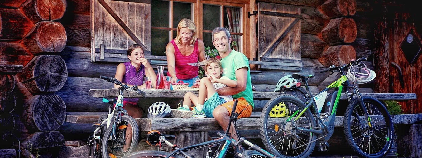 Familie mit Mountainbikes bei einer Hütteneinkehr