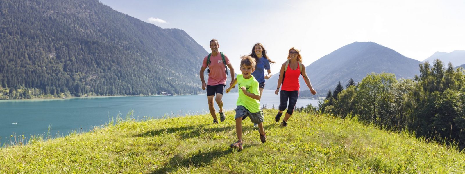 Fröhliche Familie auf Wiese oberhalb des Weissensees