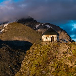 Die Kapelle auf der Arnoldhöhe oberhalb der Bergstation. Im Wolken im Hintergrund der Ankogel (3.252 m)